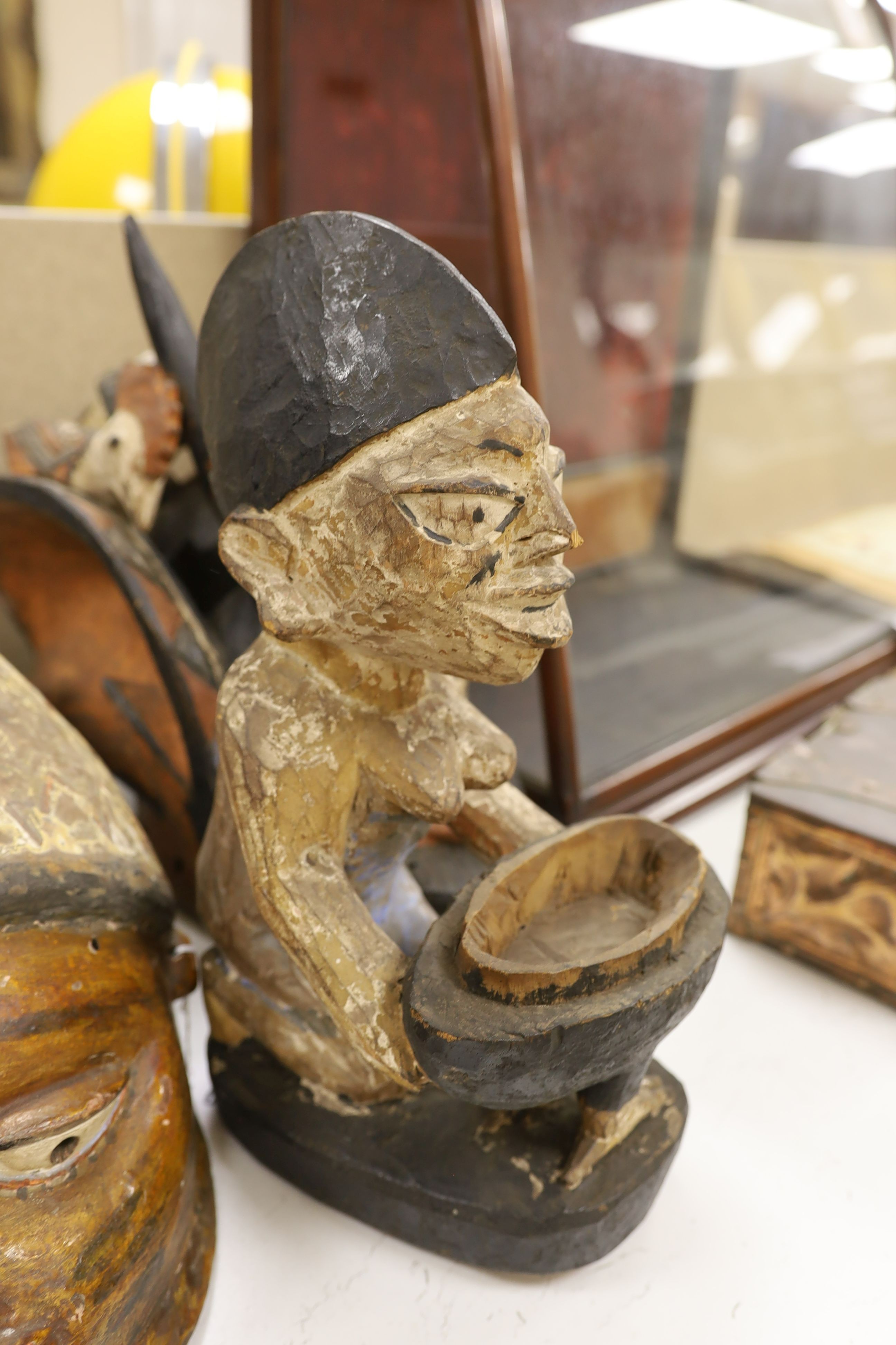 A group of West African tribal artefacts, including a Cross River Egungun mask, 48 x 20cm, a Yoruba Gelede helmet mask, 39 x 38cm and a Yoruba offering figure, 35cm, Provenance- collected by the owner’s uncle before 1960